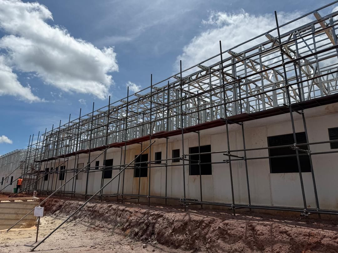 Engineers' dormitory: upper-floor steel frame going up behind scaffolding