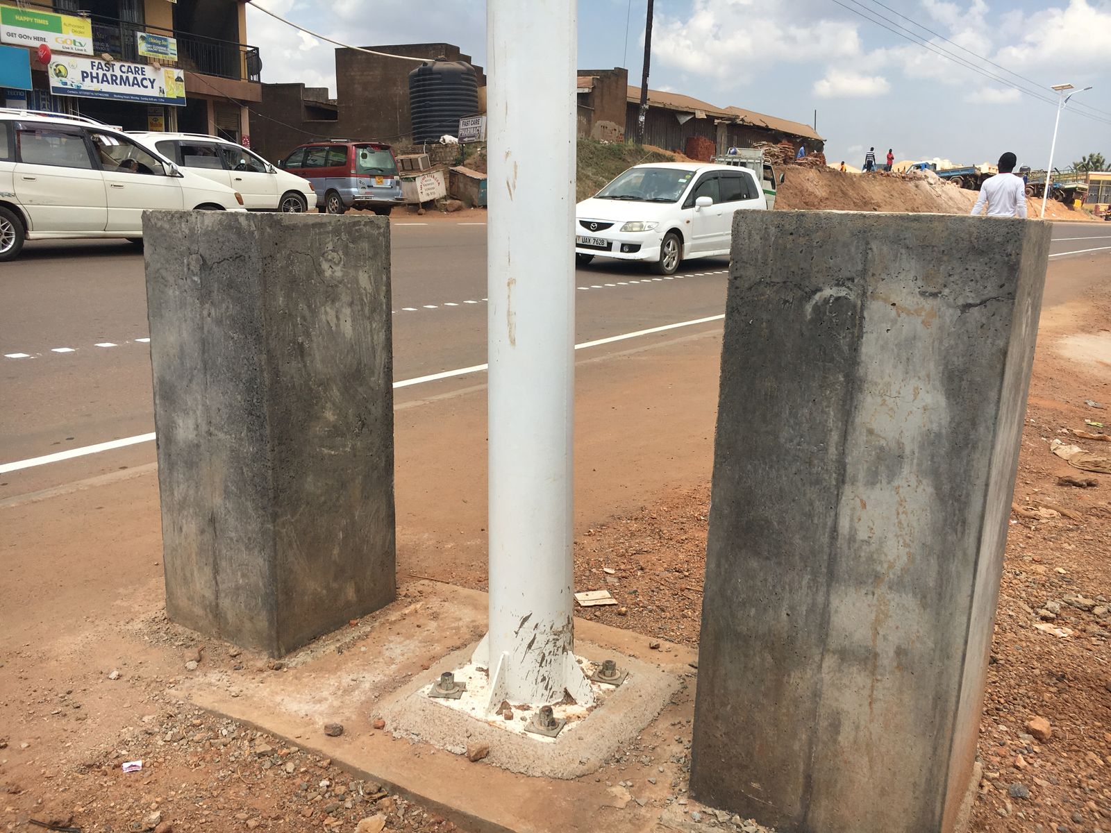 Pole bolted to its base plate between the concrete pillars