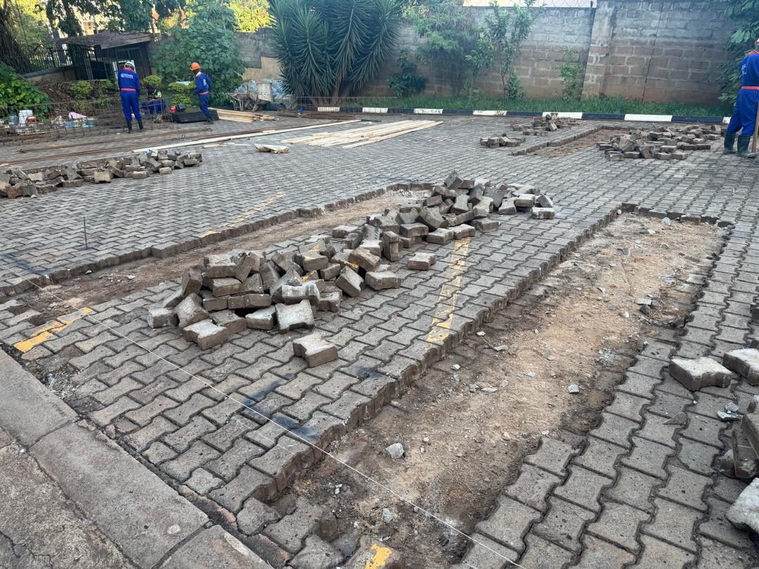 Interlocking paving lifted and stacked beside each foundation strip, ready for excavation